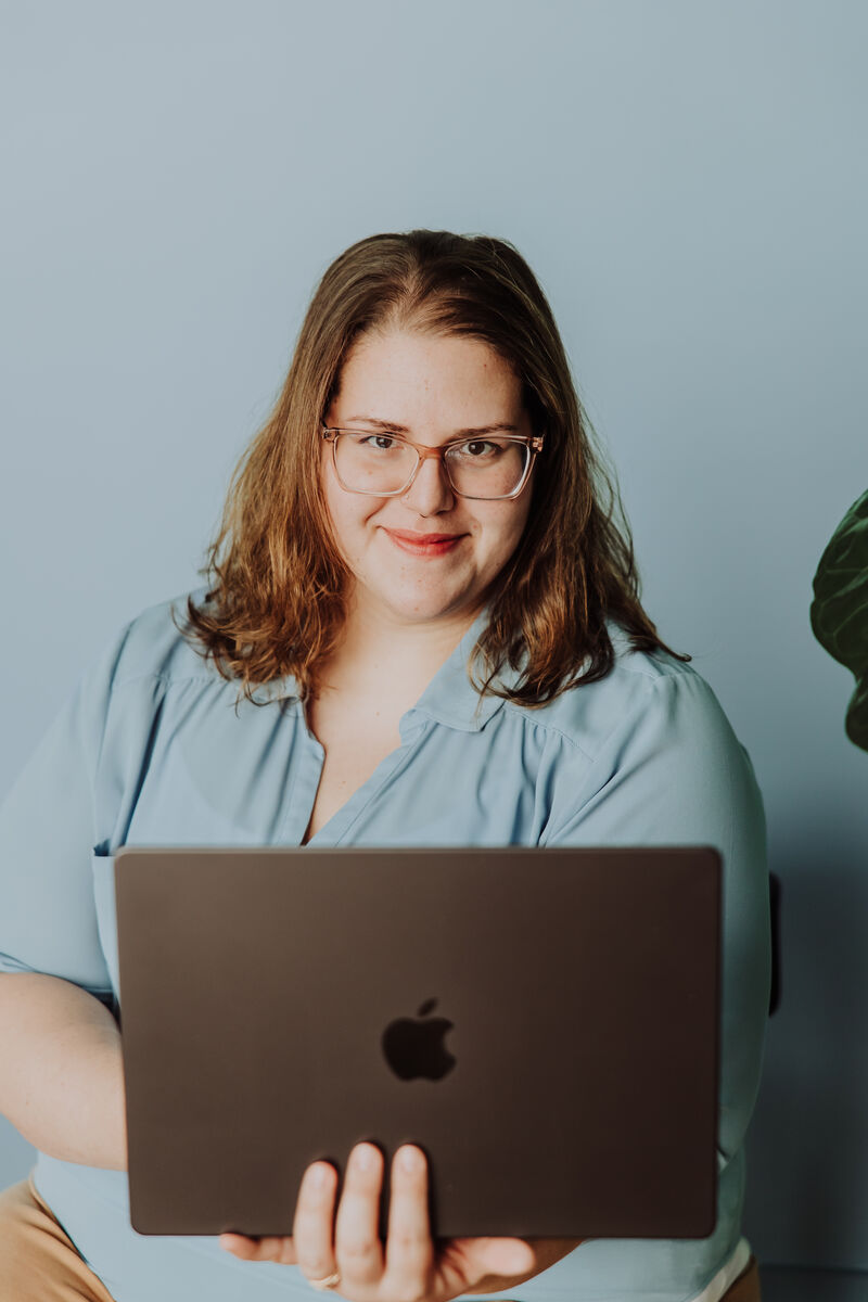 Jenn holding her open MacBook