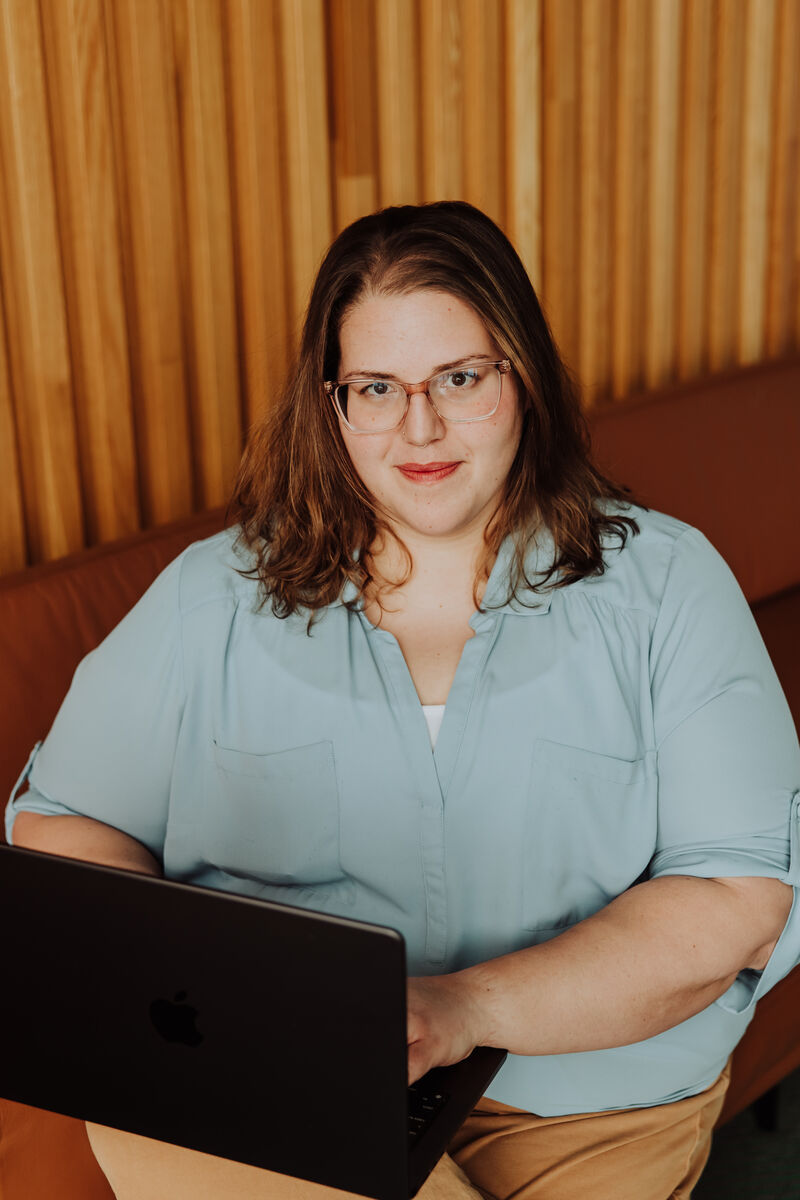 Jenn looking at the camera over her open laptop